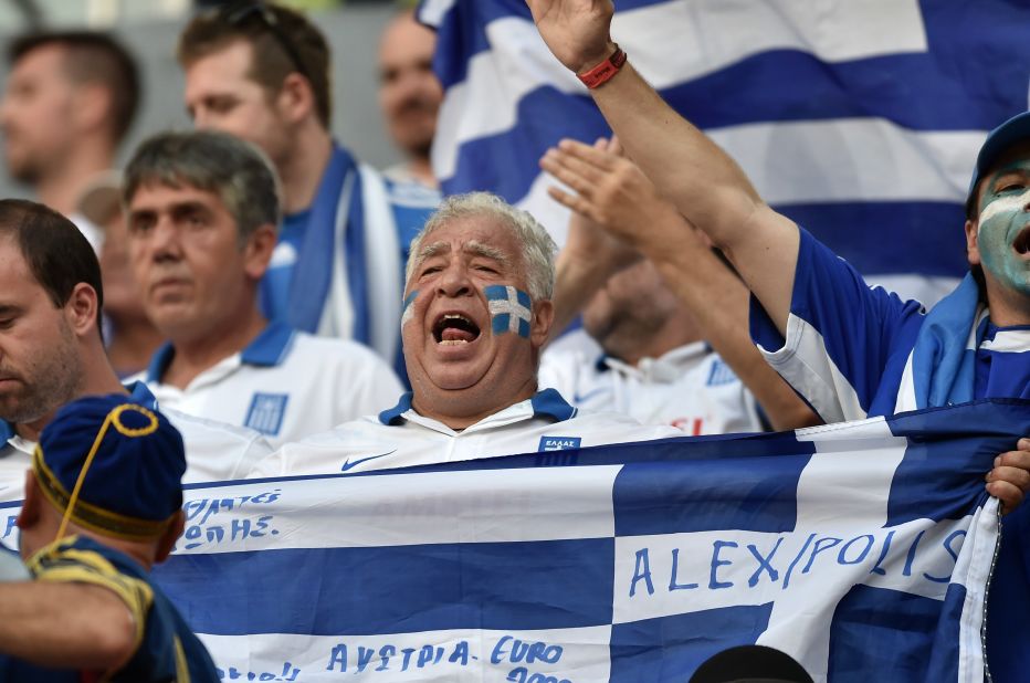 Greek fans cheer before the start of the game.