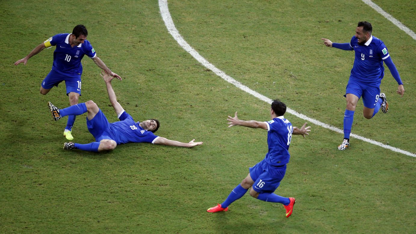 Greece's Sokratis Papastathopoulos, on the ground, celebrates with teammates after scoring his team's equalizing goal against Costa Rica.