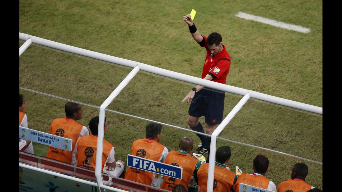 Referee Benjamin Williams gives a yellow card to Costa Rica's Oscar Esteban Granados on the sideline.