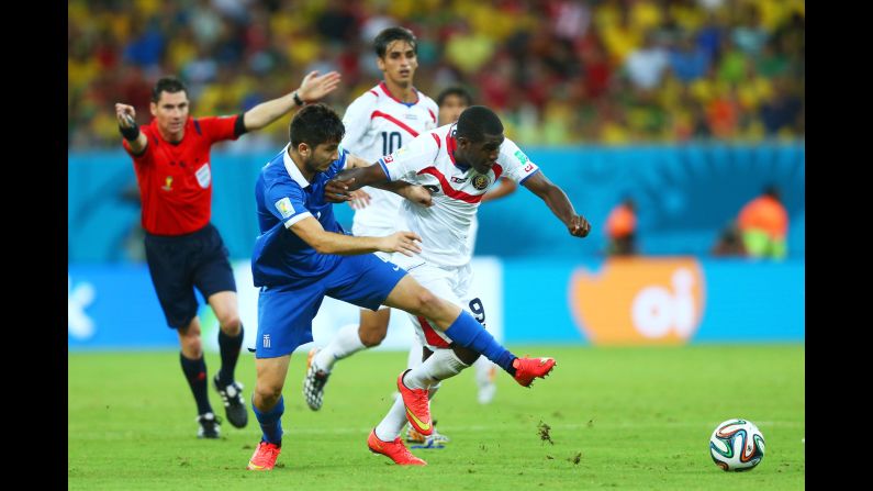 Konstantinos Manolas of Greece challenges Joel Campbell of Costa Rica.