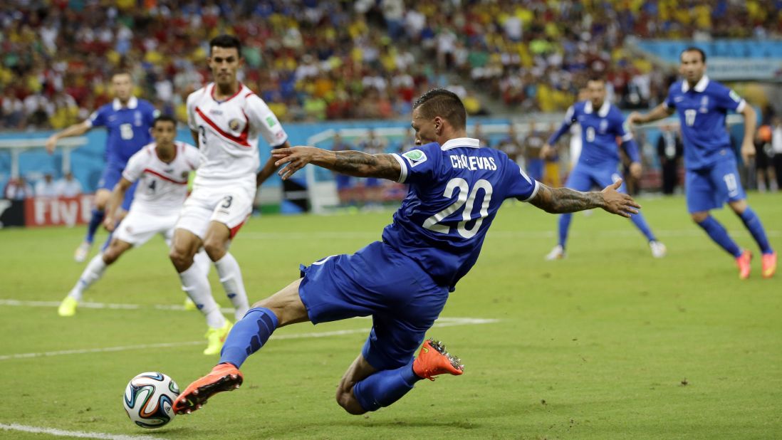 Greece's Jose Holebas runs to kick a cross during extra time before the penalty shootout.