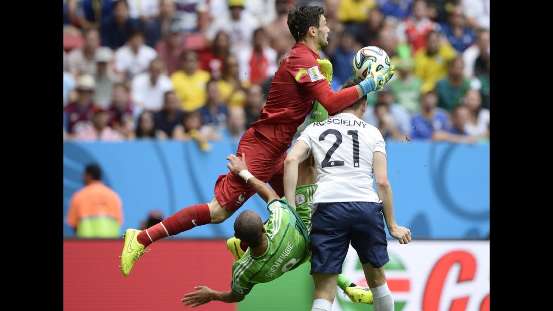 French goalkeeper Hugo Lloris collects the ball as Odemwingie attempts to score during the first half.