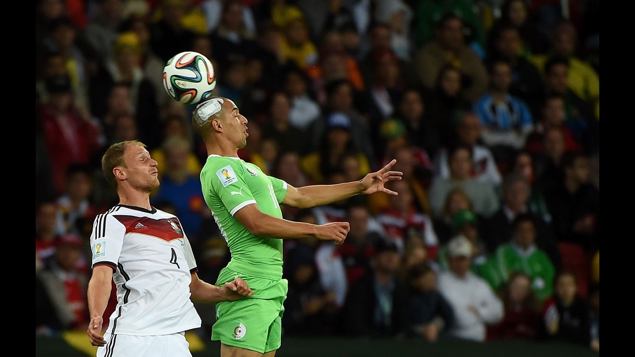 German defender Benedikt Hoewedes, left, competes for the ball with Algeria's Sofiane Feghouli.
