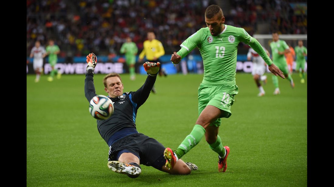 German goalkeeper Manuel Neuer, left, tackles the ball away from Algerian forward Islam Slimani.