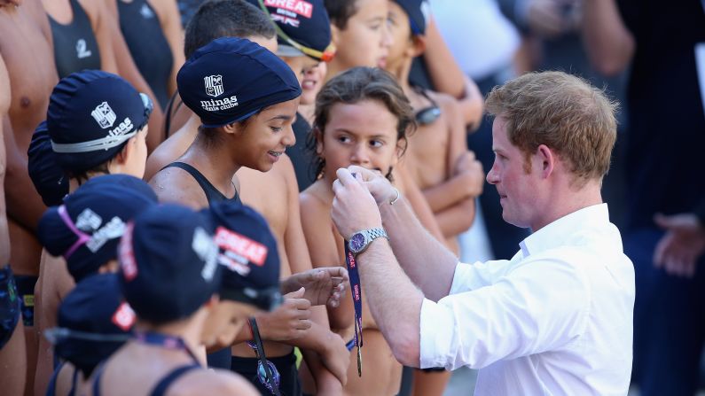 Britain's Prince Harry presents medals to young swimmers during a visit to a sports club in Belo Horizonte, Brazil, on Tuesday, June 24. He was on a four-day tour of Brazil that was followed by two days in Chile.