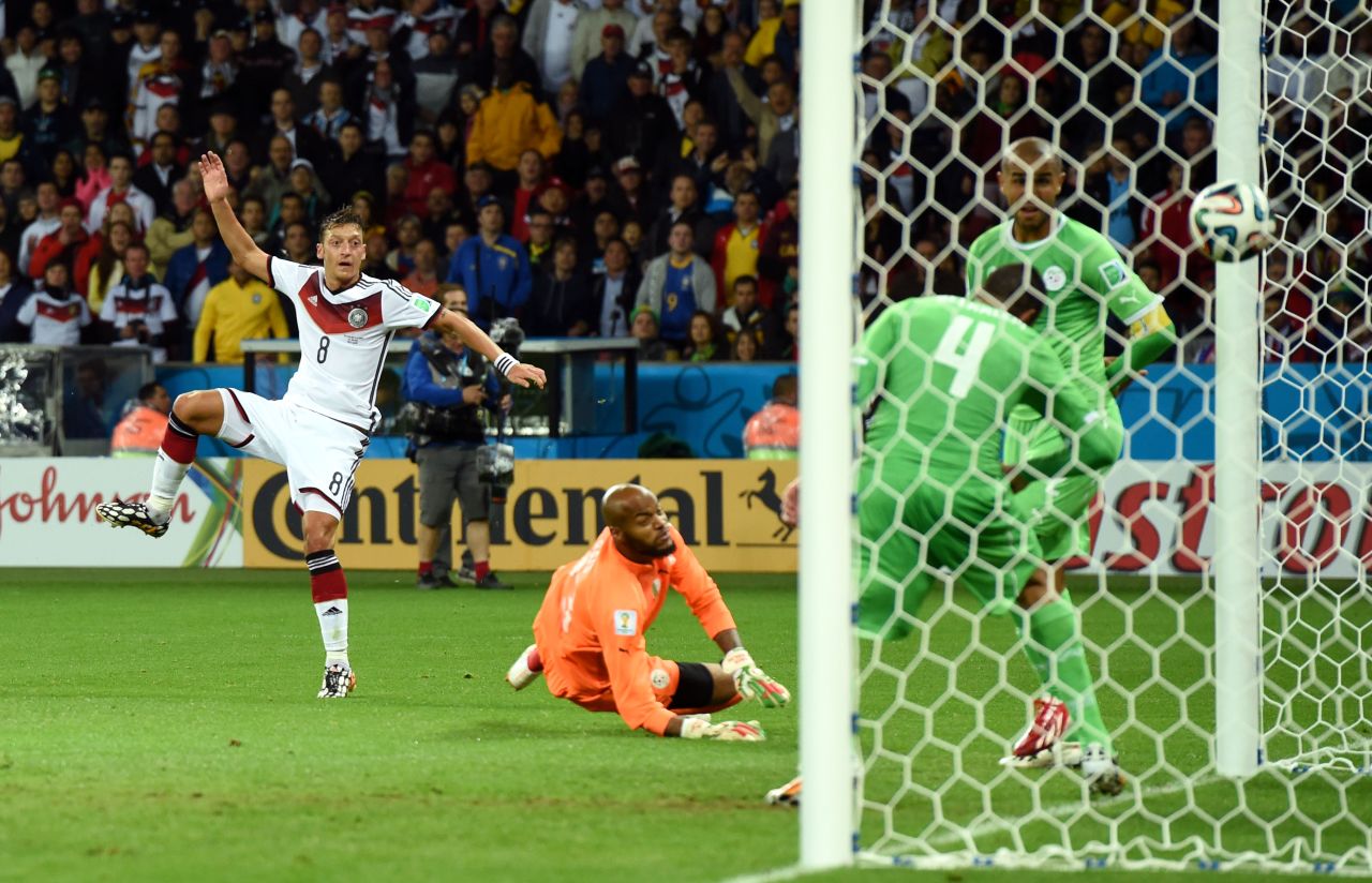 Mesut Oezil of Germany scores his team's second goal past Rais M'Bolhi of Algeria.