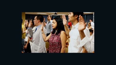 The author, Moni Basu, center, says the Pledge of Allegiance at her naturalization ceremony in 2008.