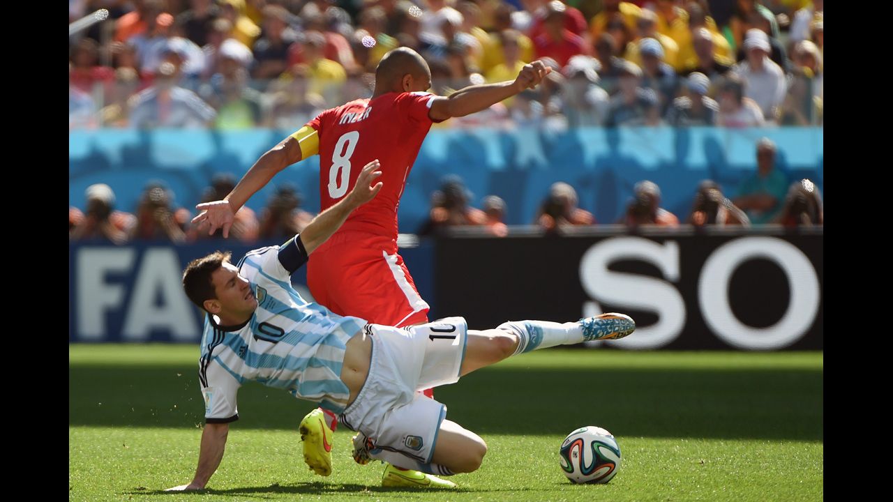 Messi and Swiss midfielder Goekhan Inler fight for the ball.