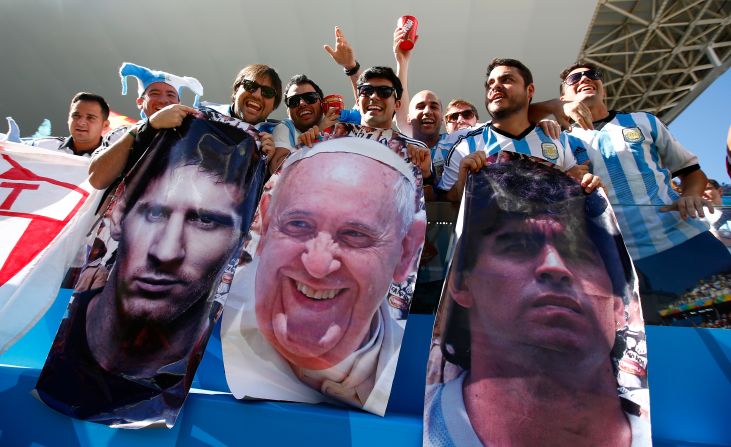 Argentina fans celebrate before the match. The faces, from left to right, are three of the world's most famous Argentines: Messi, Pope Francis and soccer legend Diego Maradona.