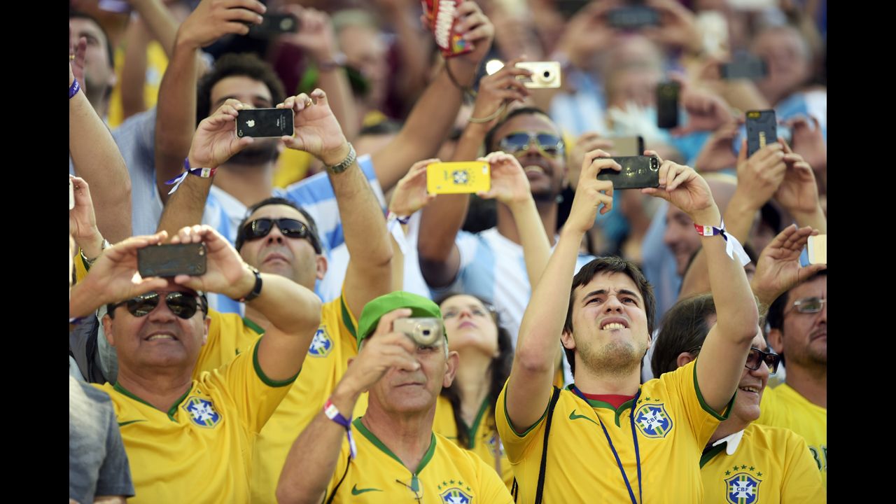 Fans wearing Brazil jerseys take pictures prior to the start of the match.