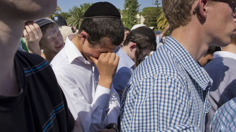 Friends of Naftali Frankel attend his funeral service.