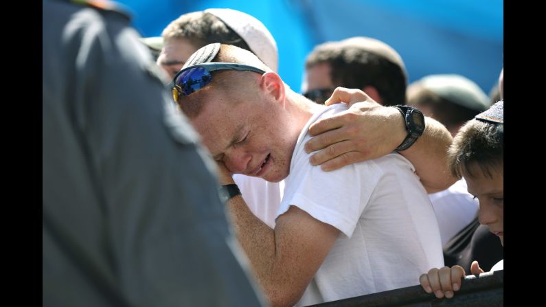 A young man grieves during Shaar's funeral.