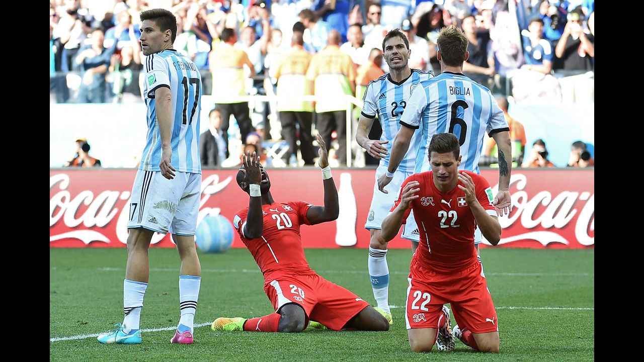 Switzerland defenders Fabian Schaer, right, and Johan Djourou, second from left, react after a missed shot.