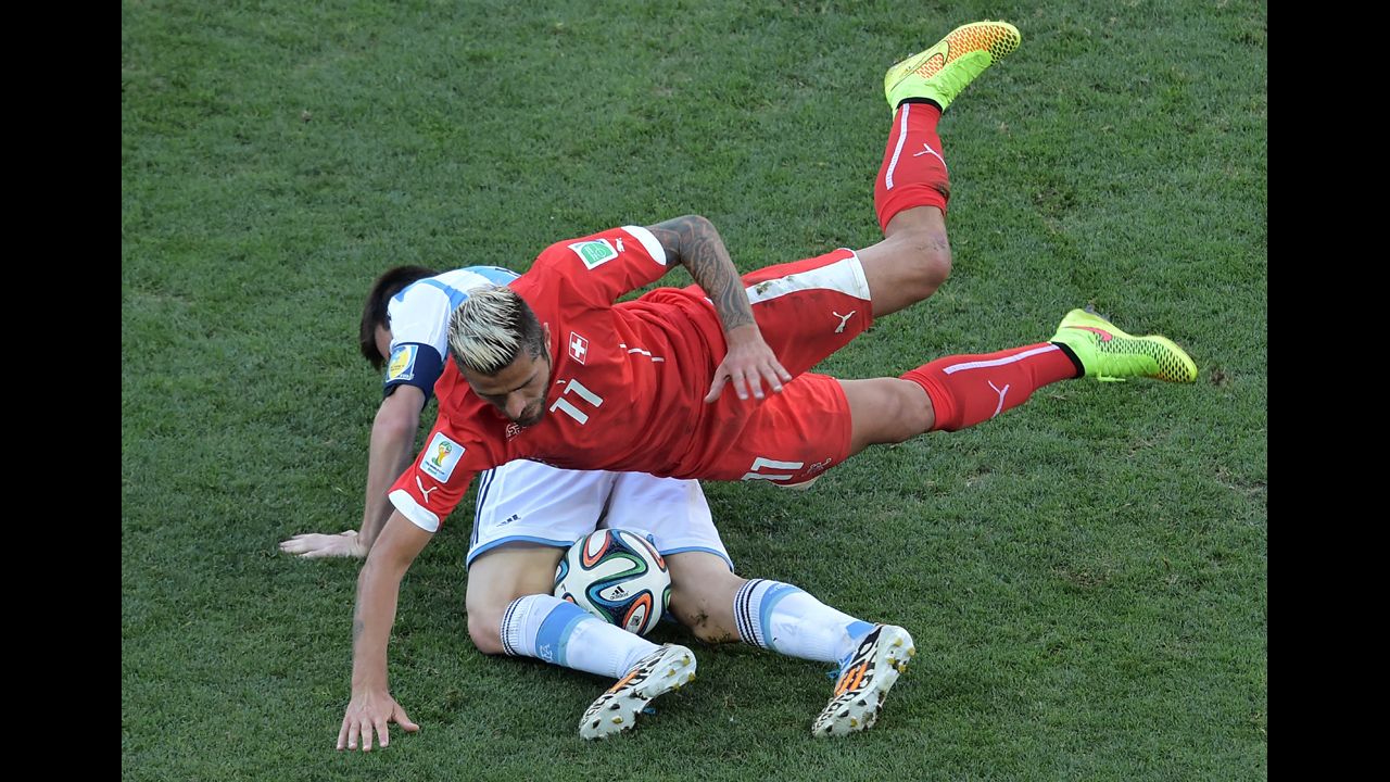 Swiss midfielder Valon Behrami falls on Messi.