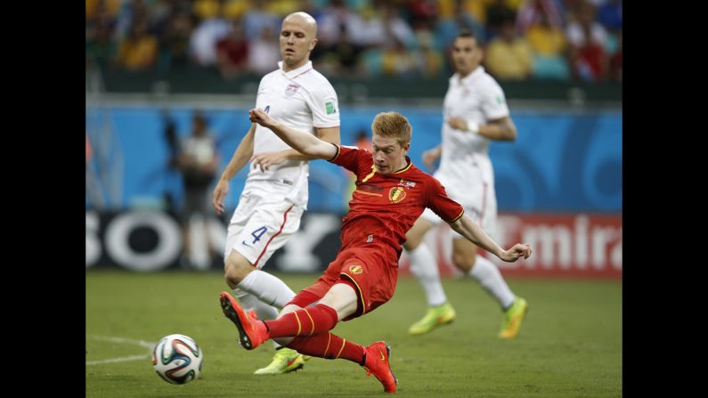 Bradley, left, looks on as De Bruyne kicks the ball.