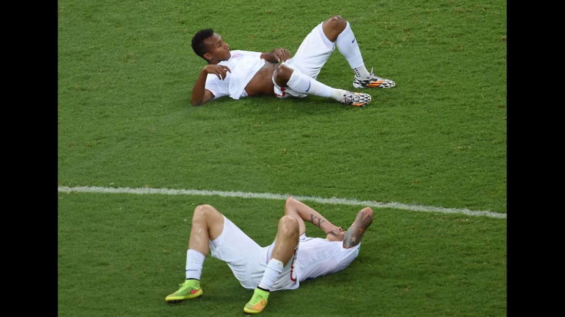 U.S. players Julian Green, top, and Geoff Cameron lie on the field after the match.