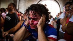 Christian Raja, of Brooklyn, reacts at a missed attempt on goal by the United during overtime against Belgium in the World Cup while watching on a projected screen under the Manhattan Bridge on July 1, 2014 in the Dumbo neighborhood of the Brooklyn borough of New York.