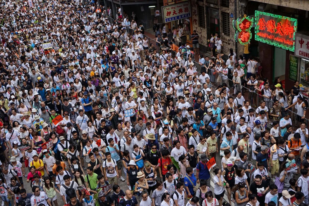 A river of protesters, wearing white T-shirts to show their support for democracy, flowed through Hong Kong's Causeway Bay. Police counted more than 98,000 participants.
