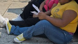 A woman with obesity sits on the sidewalk in Mexico City on May 20, 2013. Obesity among Mexicans soared from 9.5% in 1988 to 32% in 2012 and if overweight is included, up to 70%. The Mexicans also contribute with 22,000 out of the 180,000 people who die annually in the world from conditions related to the intake of sweet drinks, a figure that doubles the 10,000 deaths caused by the organized crime in the country.