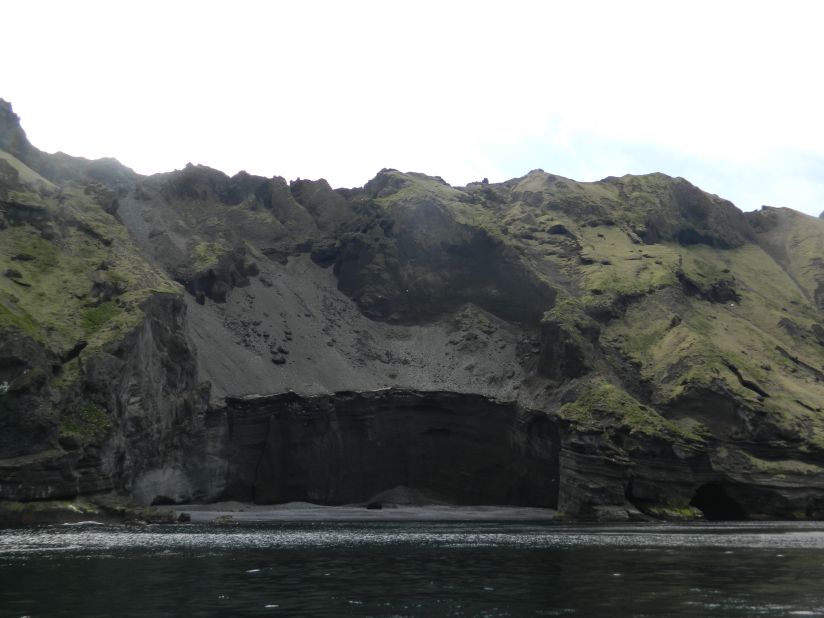 On boat rides around the Iceland's Heimaey Island, visitors pass towering banks of ash sloping down to the sea. 