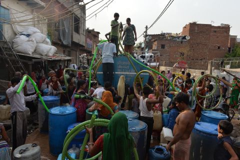 Residents fill drums from a water distribution tanker in New Delhi on June 16. Water shortages are a continuing problem in much of India, as around 150 million people have no access to clean water, according to government data.