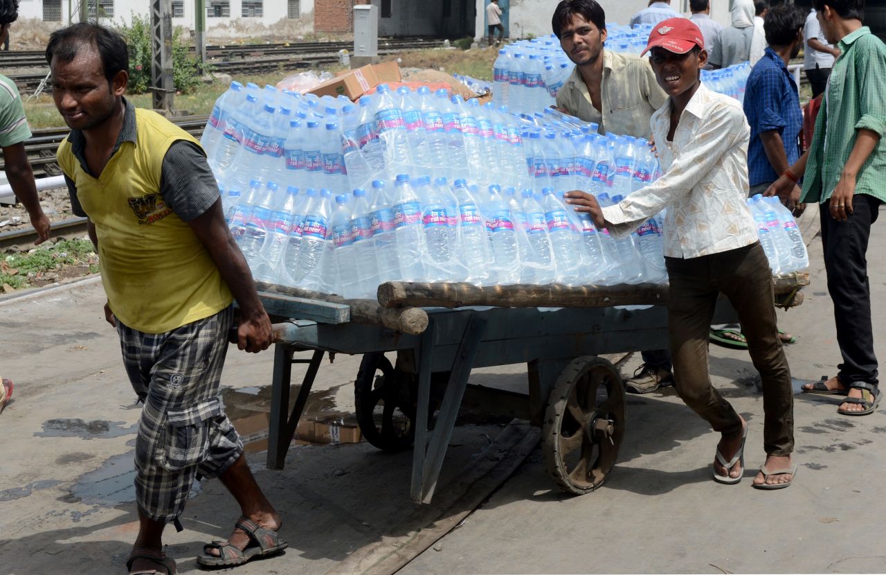 Workers in New Delhi pull a cart carrying water bottles on June 27.