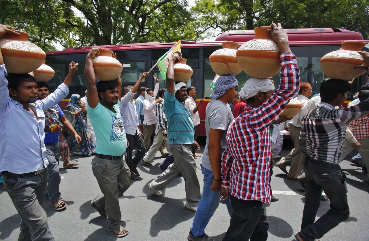 Activists carry pots on their heads June 13 during a protest march against power cuts and water problems in New Delhi.