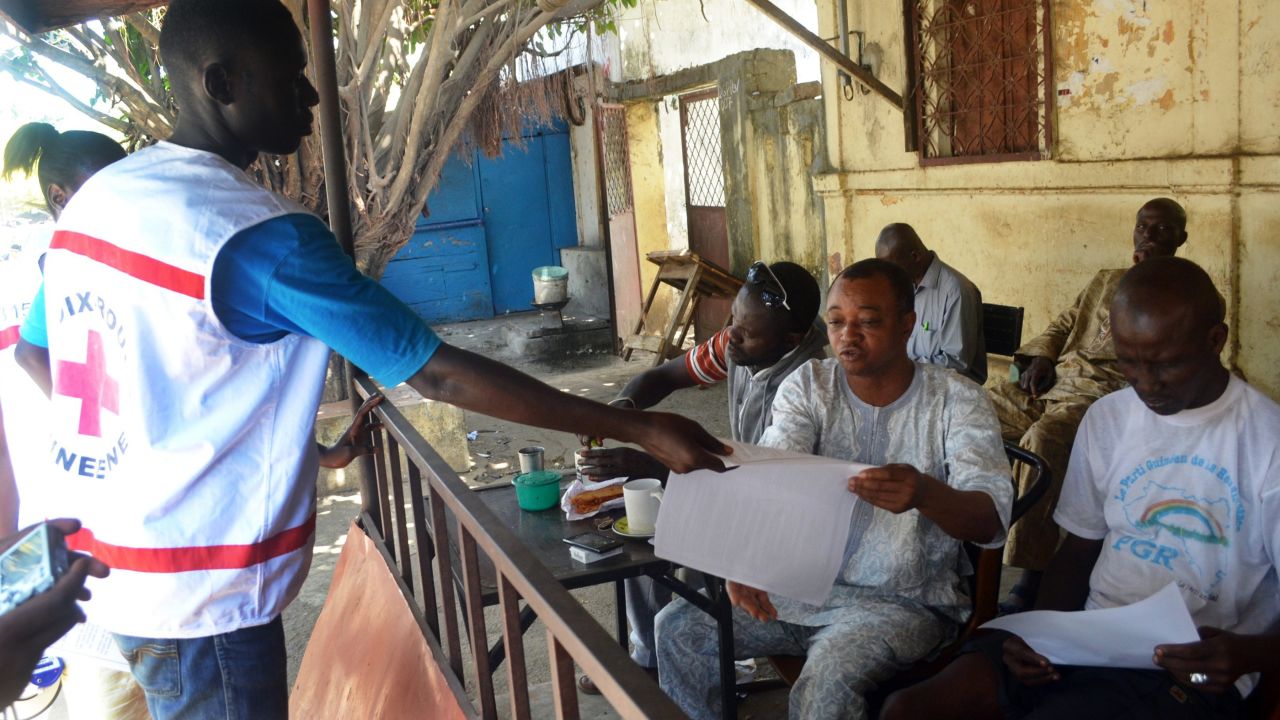 Members of the Guinean Red Cross distribute information leaflets during an awareness campaign on the Ebola virus on April 11, 2014 in Conakry. Guinea.