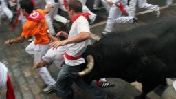 A young man is caught between the bull's horns as he is tossed on July 8, 2007 in the old city streets of Pamplona. Thousands of "runners" test their skill, courage, and luck in the 900-meter course made famous by Ernest Hemingway's 1926 novel "The Sun Also Rises." first published in 1926. The man was thrown against a fence but not injured.