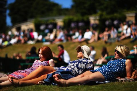 Spectators soak up some sun on "Murray Mound" in the grounds of the All England Club.