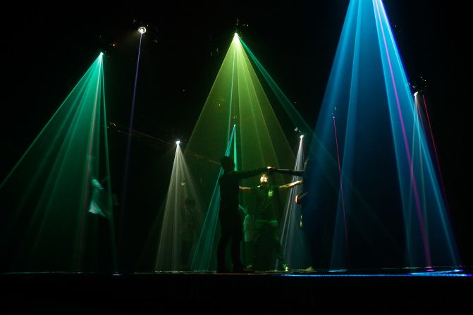 "Assemblance" by Umbrellium features a blacked-out room filled with three-dimensional light fields that visitors can walk through and manipulate  with their bodies to create luminous forms and release puffs of smoke and bubbles.     