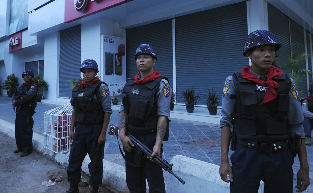 Myanmar police guard on a street in Mandalay, after imposing an overnight curfew in the country's second largest city. The curfew was introduced after two nights of religious violence between Buddhists and Muslims that left two people dead.