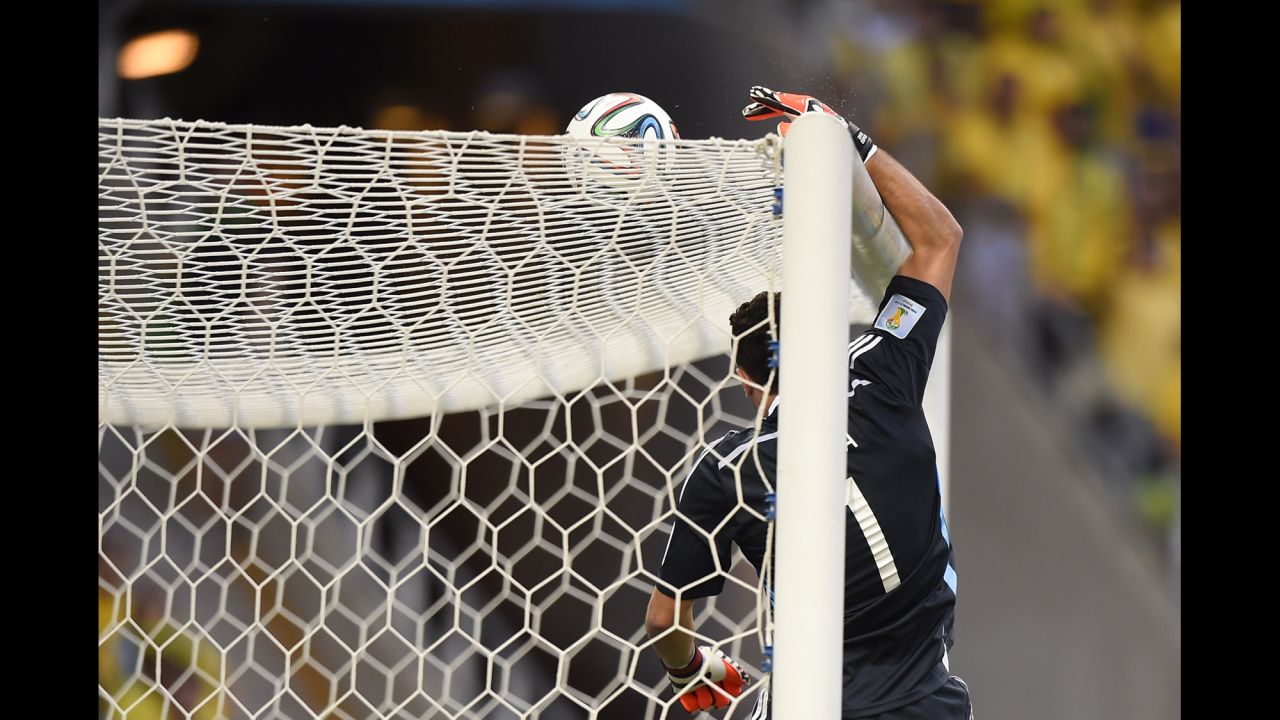 Colombian goalkeeper David Ospina tips a ball over the crossbar.