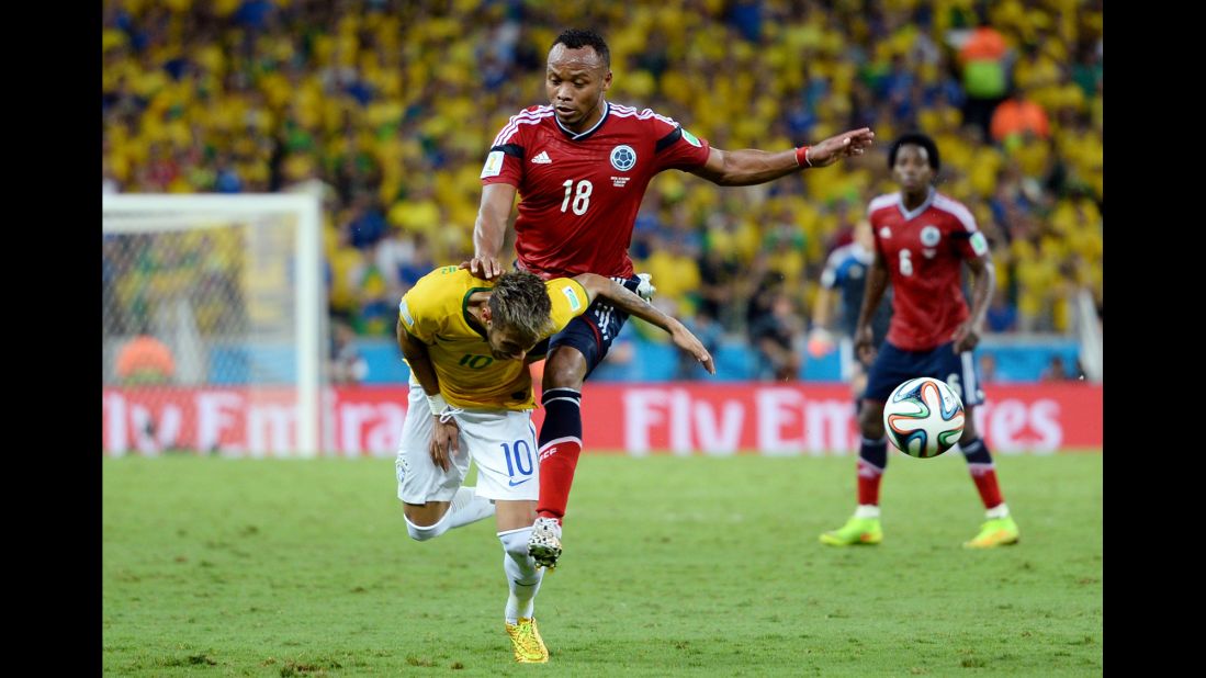 Neymar of Brazil is challenged by Juan Camilo Zuniga of Colombia. 