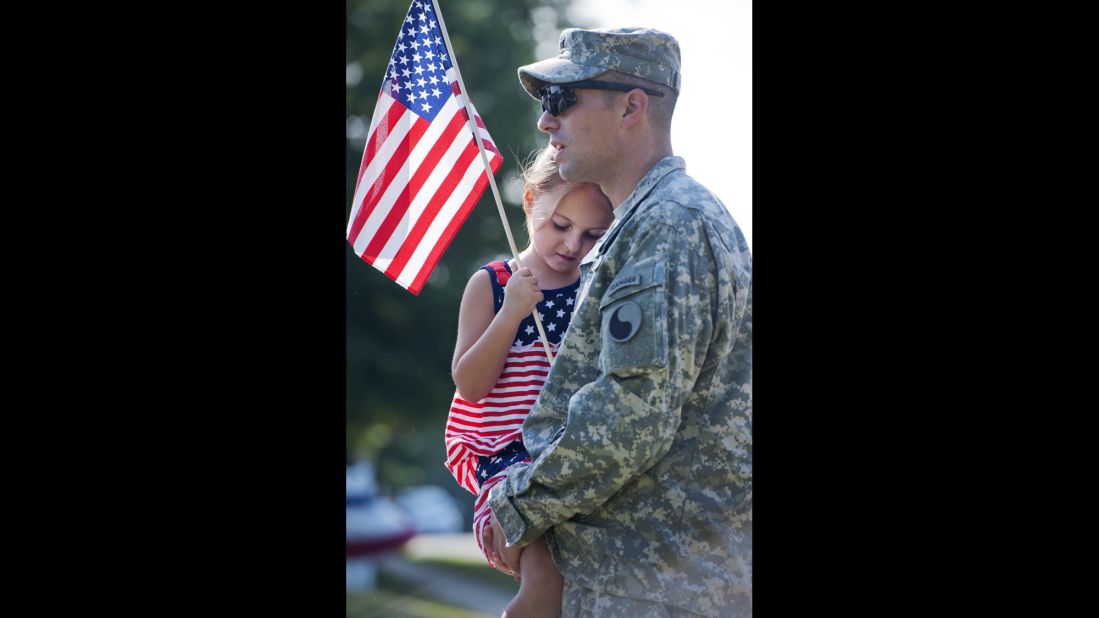 Capt. Brandon Price of the Virginia National Guard and his daughter Chloe prepare to march in a parade in Leesburg, Virginia.