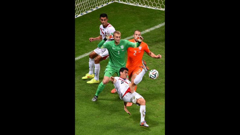 Johnny Acosta of Costa Rica attempts a shot on goal against goalkeeper Jasper Cillessen and Ron Vlaar of the Netherlands.
