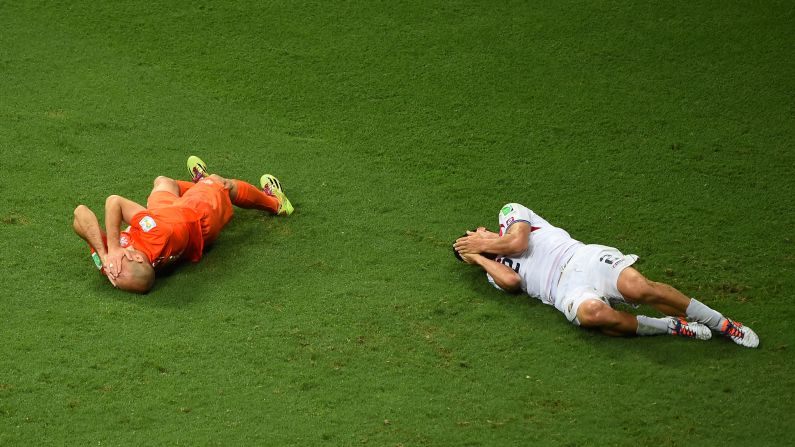 Arjen Robben of the Netherlands and Johnny Acosta of Costa Rica lie on the pitch after a collision.