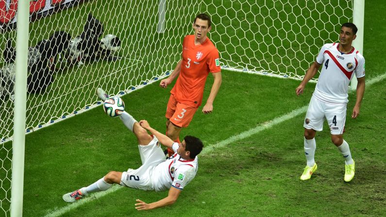 Costa Rica's Johnny Acosta, left, tries to kick the ball.