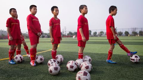Young Chinese students wait for a kick during training at the Evergrande International Football School.