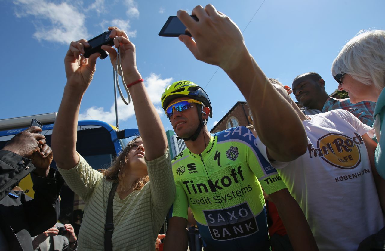 Two-time champion Alberto Contador takes a 'selfie' with some fans before the start of stage two. The 'selfie' fad is making a big impression on this year's Tour, although it has sparked safety fears among the riders.<br />