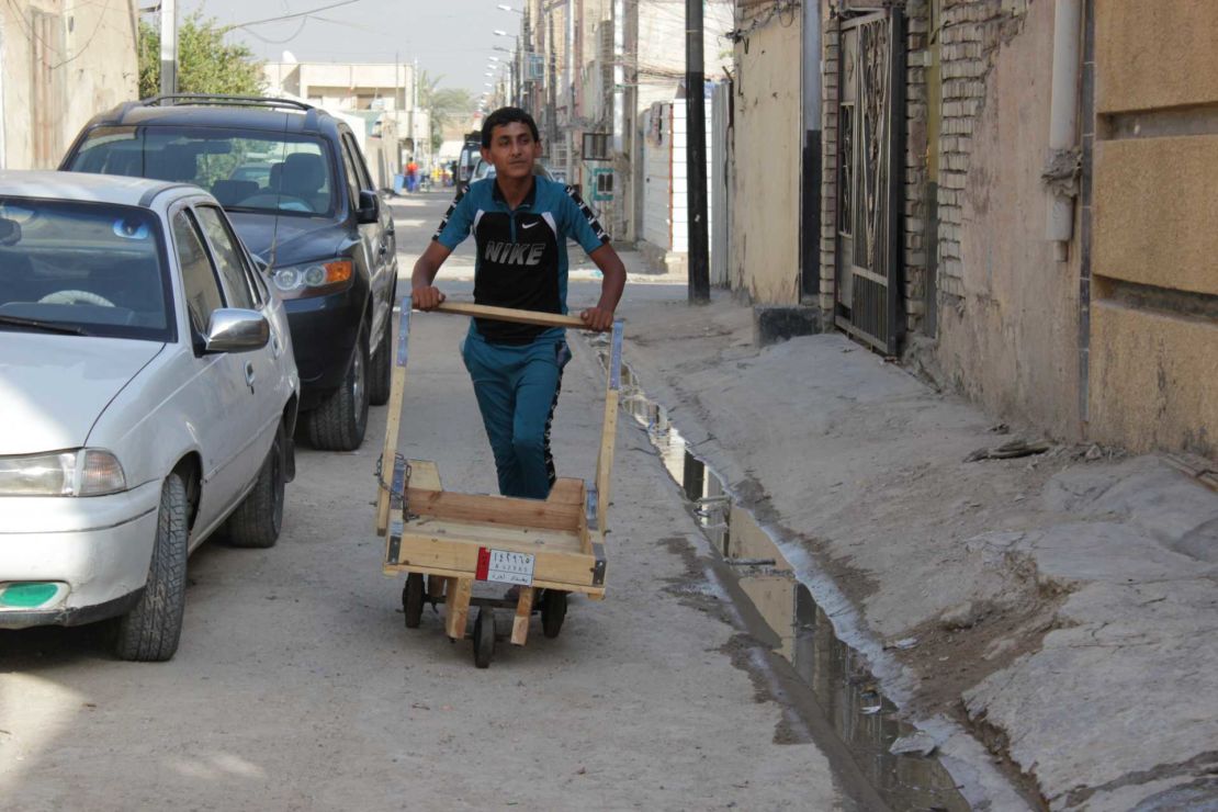 Mustafa, 15, pushes a trolley he uses in his day job transferring goods across the area to help support his family.