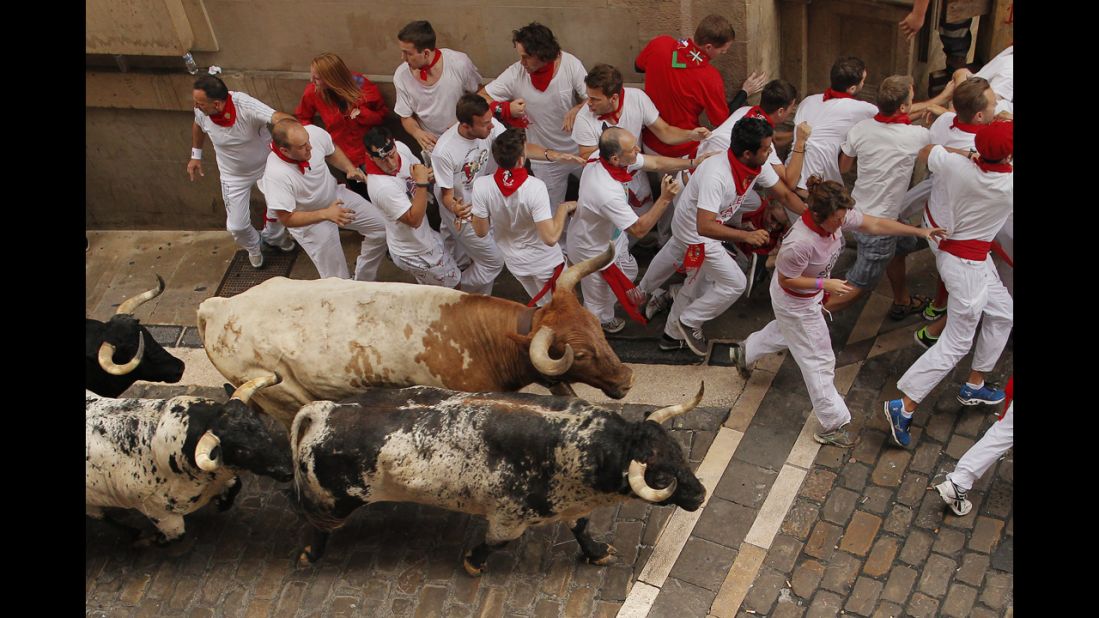 Bulls and revelers run through Pamplona's streets on July 7. 
