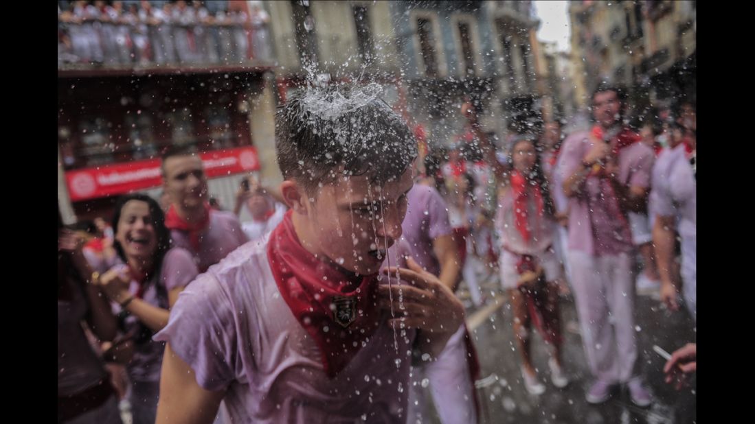 Revelers have water thrown on them from a balcony to celebrate the official opening of the San Fermin festivities on Sunday, July 6. 