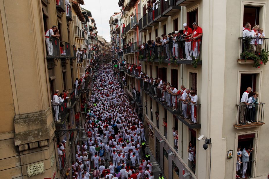 Revelers wait to run with the bulls along Calle Estafeta on July 7.