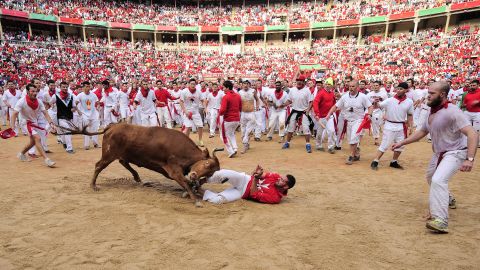 A reveler is pushed by a bull in the bull ring on Tuesday, July 8.