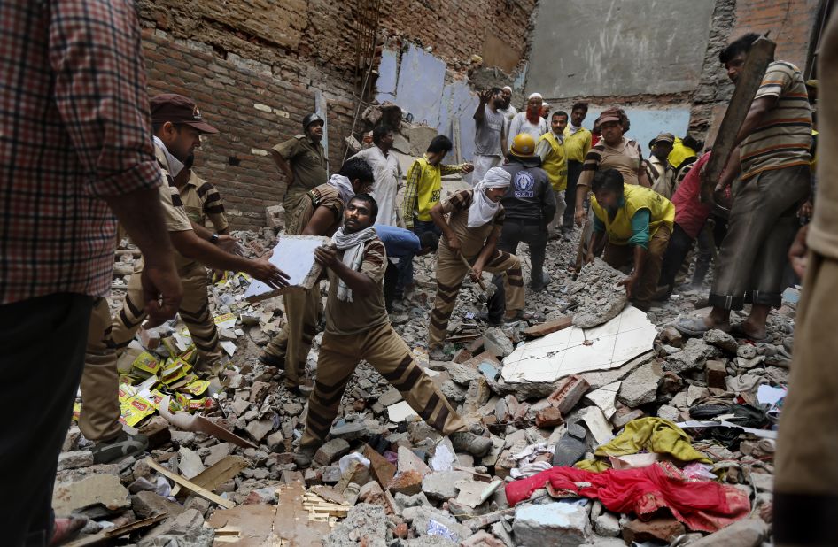 Rescue workers clear debris at the site of the building collapse on June 28.
