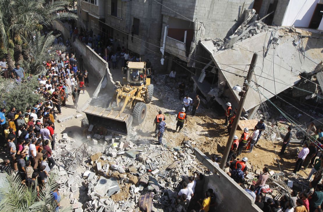 Palestinian rescue workers use a bulldozer to remove debris following an Israeli air strike in Khan Yunis.