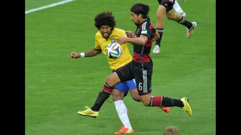Brazilian defender Dante, left, fights off Germany's Sami Khedira.