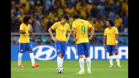 Brazilian players Oscar and Fred hang their heads after a German goal.