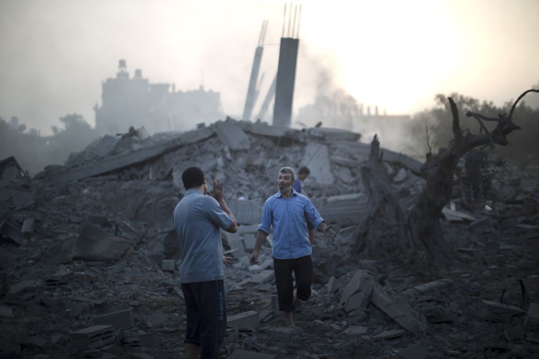 Palestinians inspect destroyed buildings following an Israeli military strike in Gaza City on Tuesday.